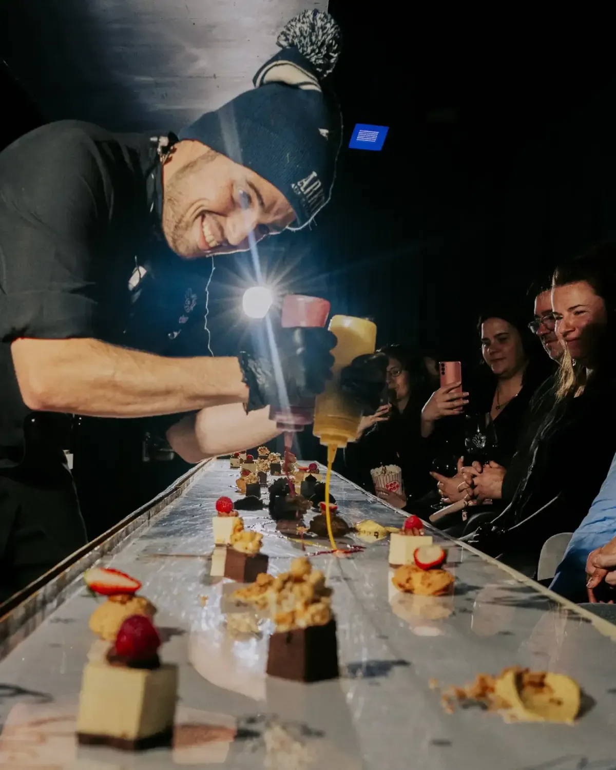 Chef Rony plating dessert down the long table