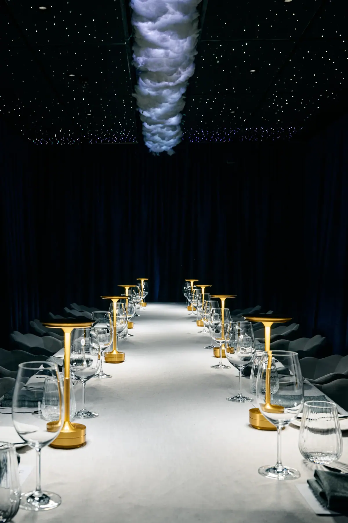 Gold lamps and glassware down the long table before the guests arrive